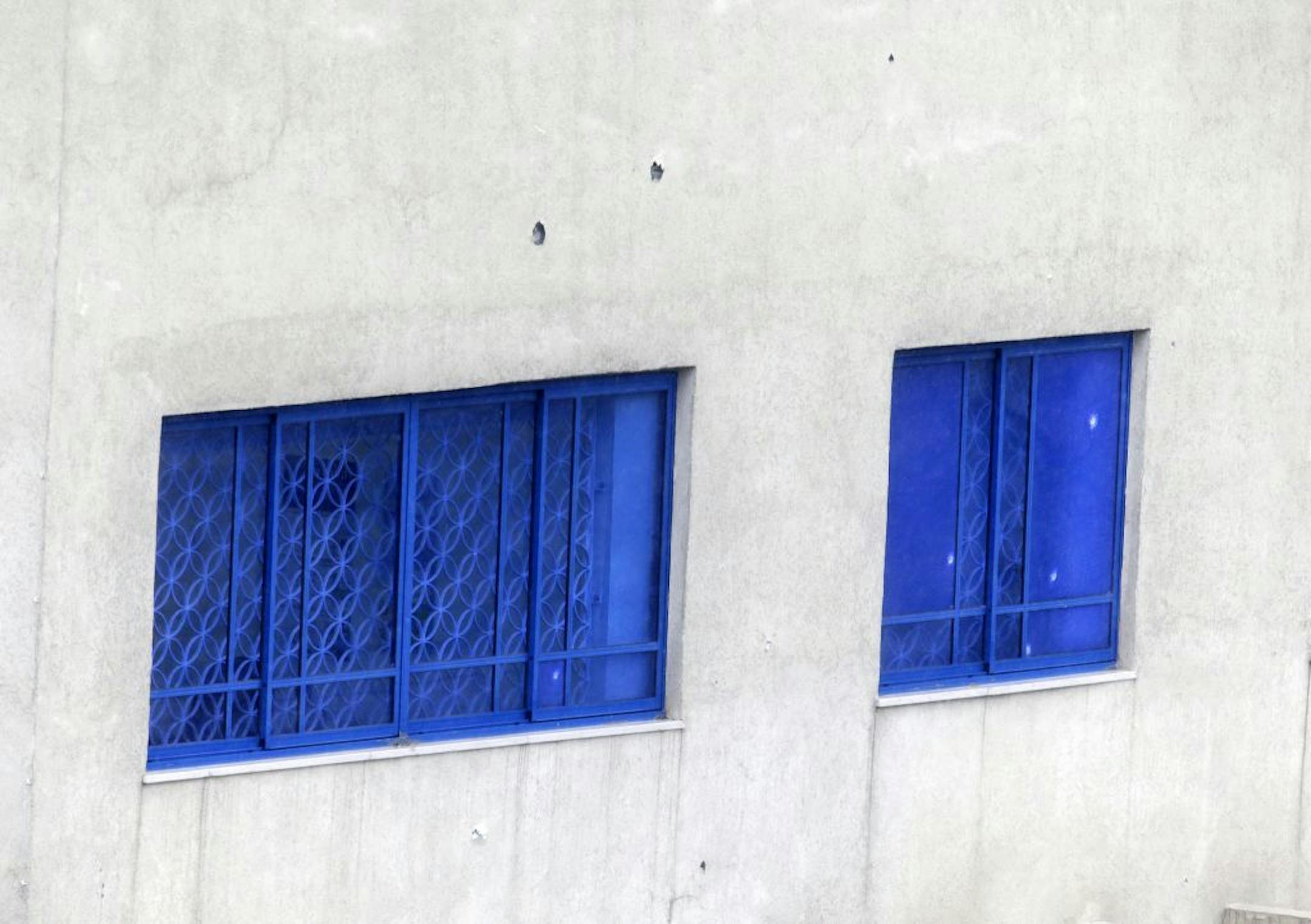 Bullet holes are seen on the wall of Israeli Embassy after a pre-dawn gunfire attack in Athens, Friday, Dec. 12, 2014. Greek authorities are investigating the pre-dawn, drive-by gunfire attack on the Israeli embassy and officials said at least 20 bullet casings were found near the scene of the attack, which occurred long before the building opened for business.