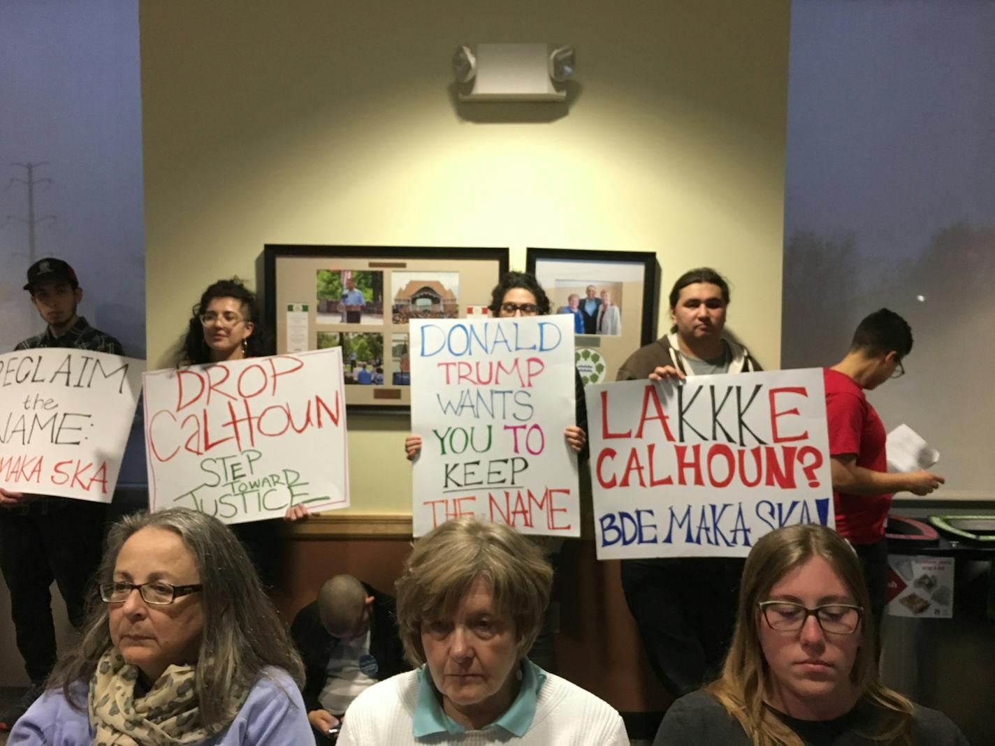 Citizens held signs asking that the name of Lake Calhoun be changed at Wednesday night's Minneapolis Park Board meeting.