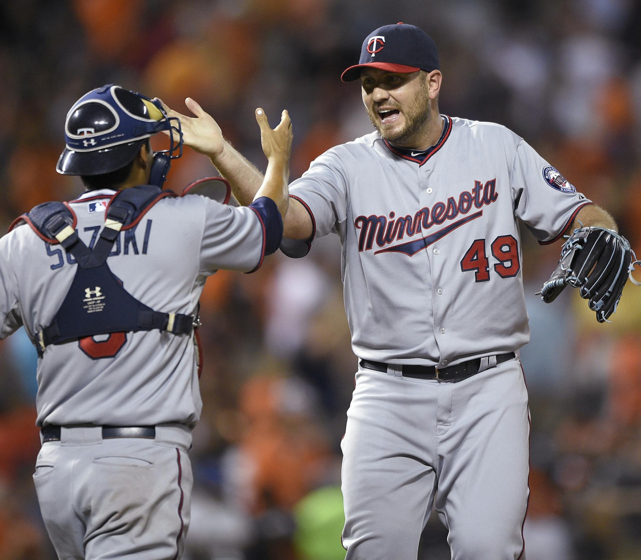 Minnesota Twins relief pitcher Kevin Jepsen (49) celebrates with catcher Kurt Suzuki, left, after the Twins defeated the Baltimore Orioles 3-2 in a baseball game, Saturday, Aug. 22, 2015, in Baltimore. (AP Photo/Nick Wass)