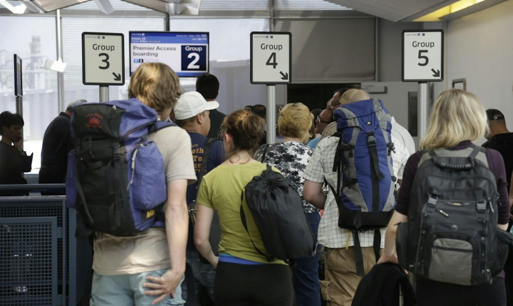 In this photo taken May 8, 2013, groups of passengers wait at a United Airlines gate to board a flight in separate numbered lanes at O'Hare International Airport in Chicago. For airlines, every minute that a plane sits at the gate makes it more likely that the flight will be late, hurting the carrier�s on-time rating and causing passengers to miss connecting flights. But the perfect boarding process remains elusive. Even an astrophysicist couldn�t figure it out.