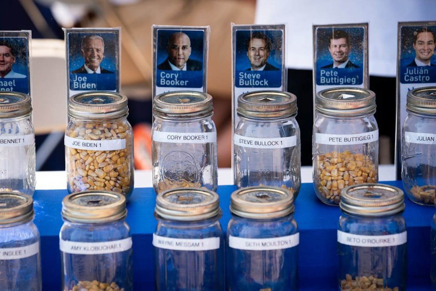 Mason jars for an informal kernel poll of presidential candidates at the Iowa State Fair in Des Moines on Aug. 9. The crowded and divided Democratic candidate field has also introduced a new phenomenon: Undecided Democrats putting their cash behind multiple candidates simultaneously.