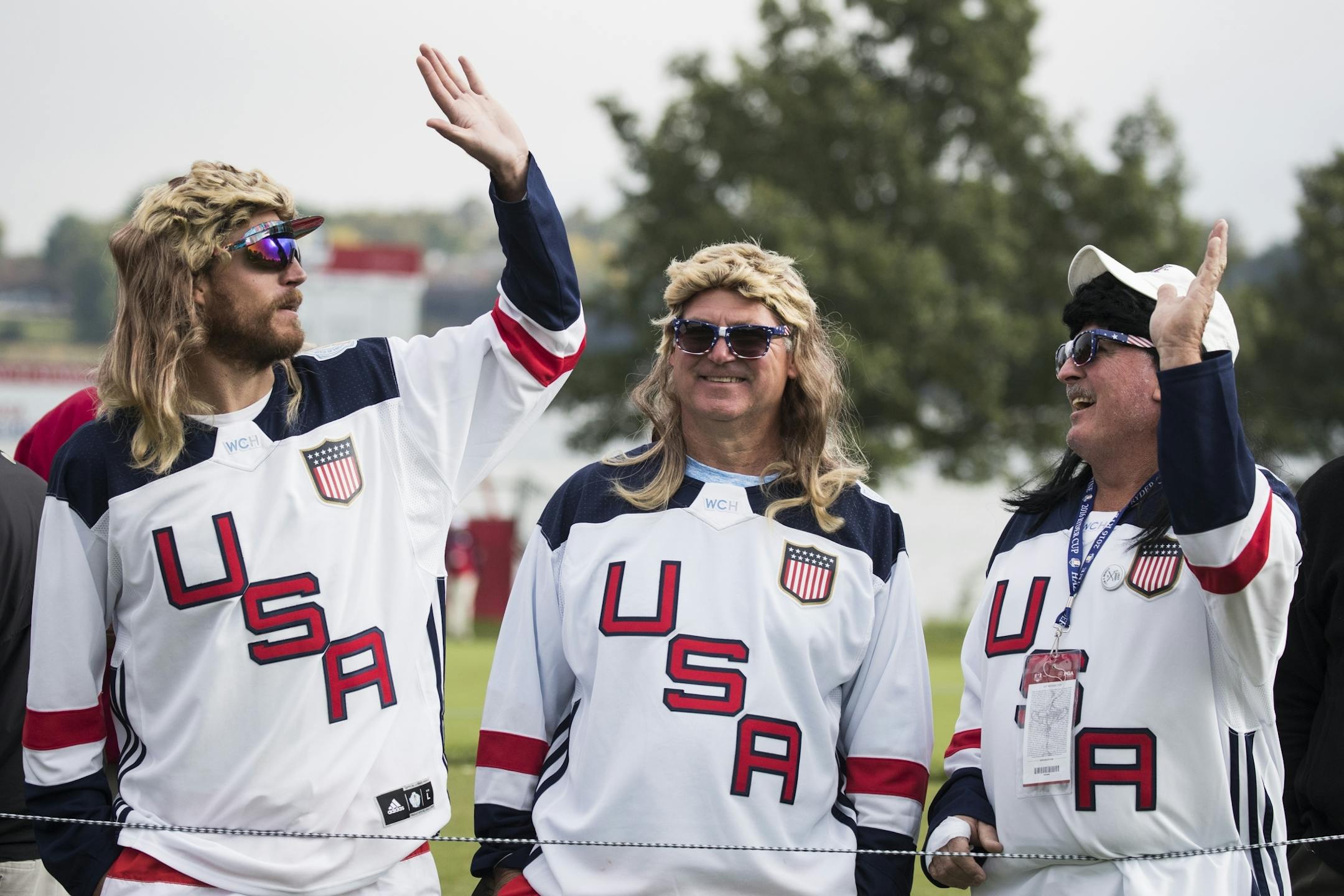 Bryan Harris, of Denver, from left, Jerry Shafrath of Iowa, and Jerry Harris of St. Louis high five while watching the action.