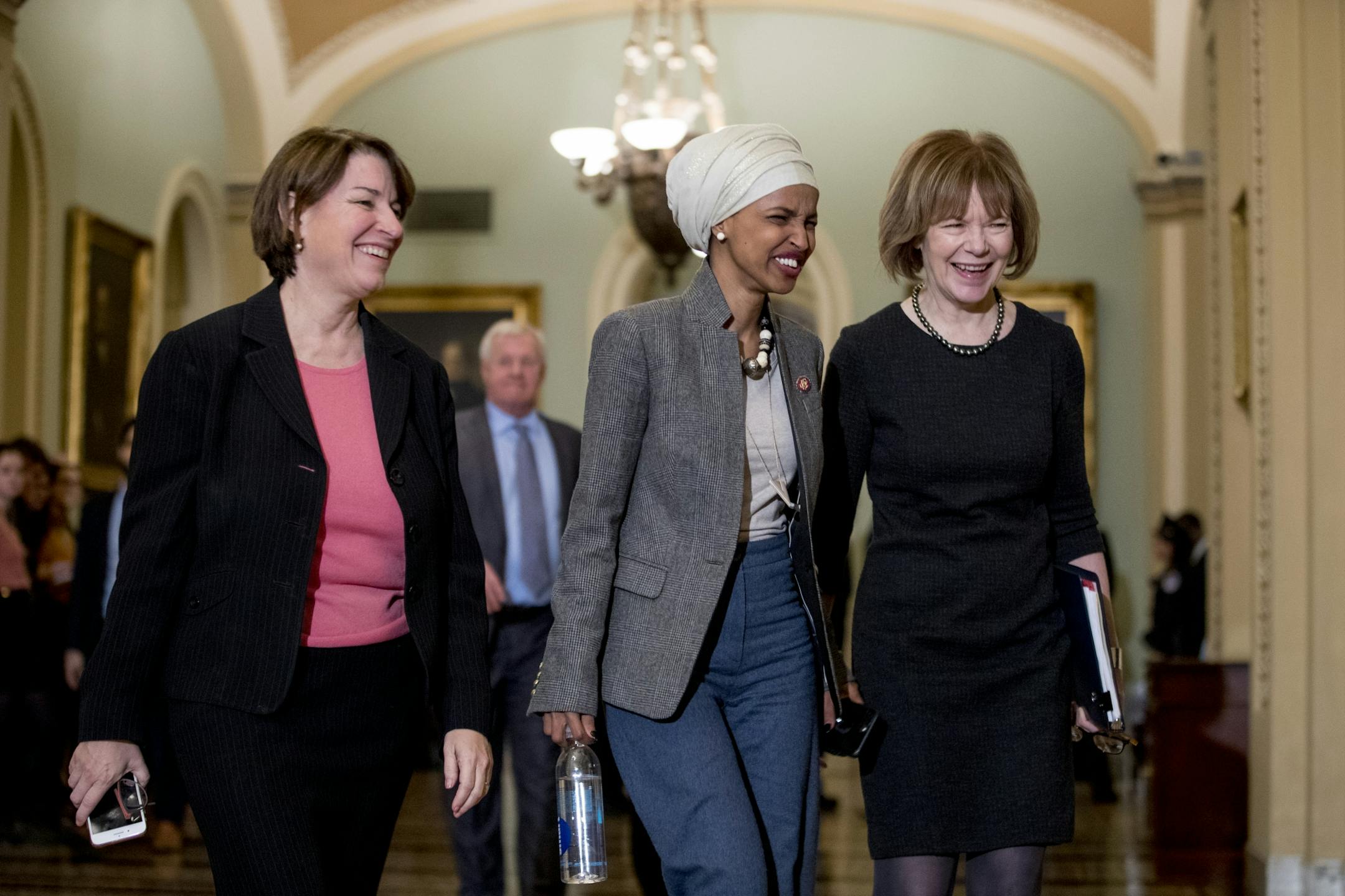 Sen. Amy Klobuchar, left, walks past the Senate chamber with Rep. Ilhan Omar and Sen. Tina Smith in 2019.