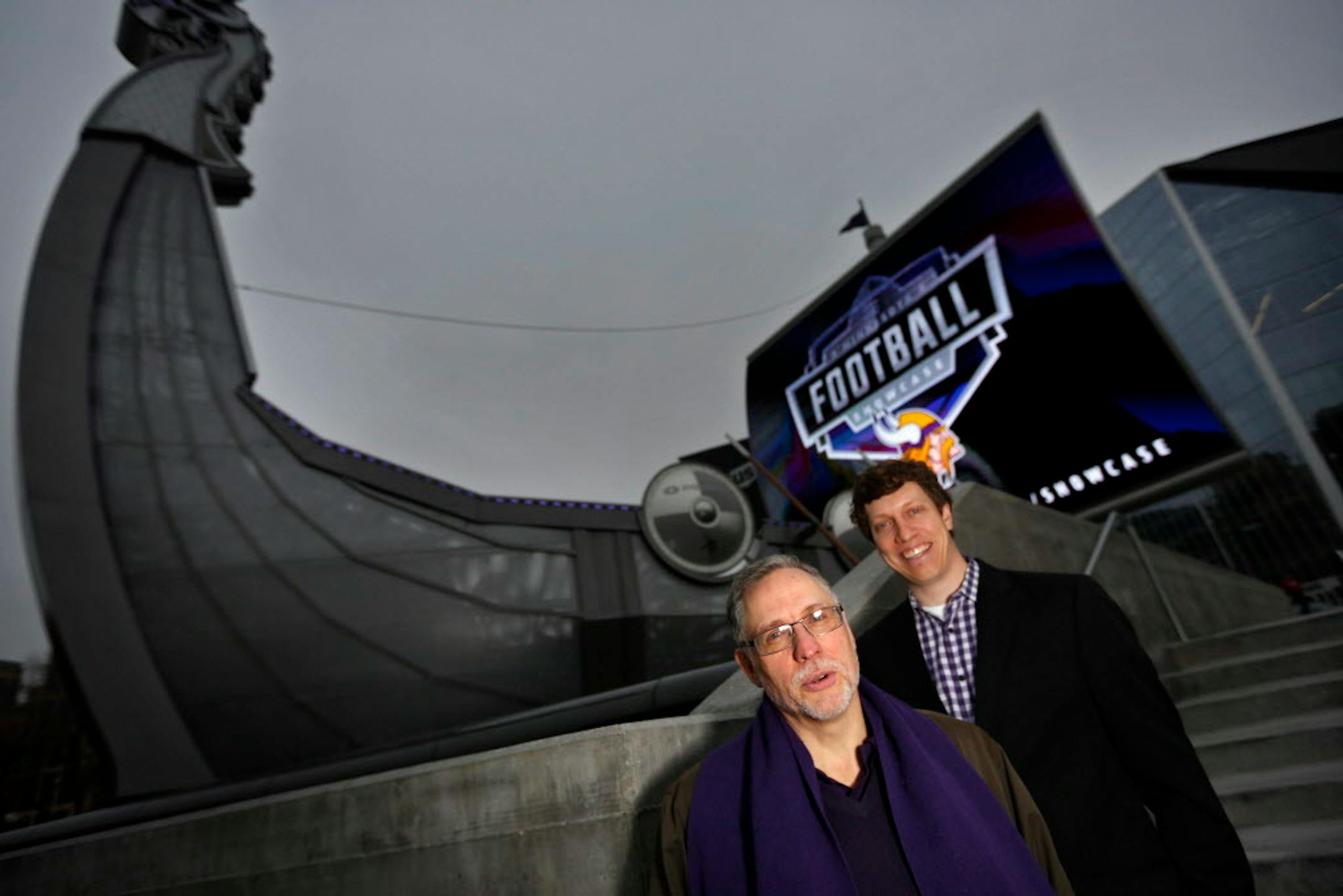 Swedish rune expert Henrik Williams, left, and Minnesota Vikings marketer Brett Taber explain to fans the mythology of the real Vikings. They're pictured by the Legacy Ship at U.S. Bank Stadium.