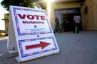 FILE - In this Oct. 30, 2020 file photo a sign directs people where to vote at a polling place during early voting in Las Vegas. Donald "Kirk" Hartle,