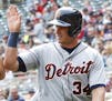 Detroit Tigers' James McCann right, high-fives with Tyler Collins after McCann scored on a two-run double by Ian Kinsler off Minnesota Twins pitcher J