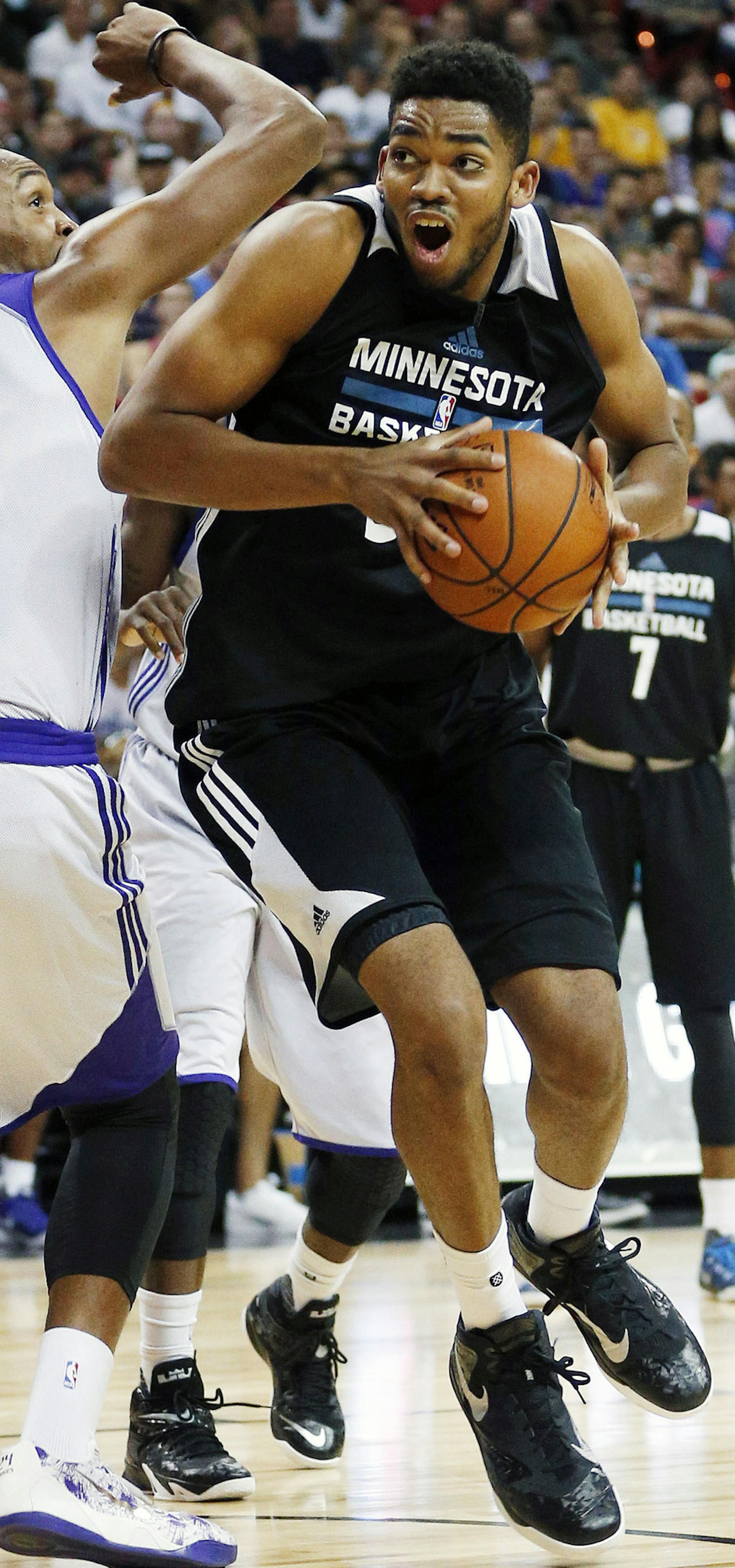 Minnesota Timberwolves’ Karl-Anthony Towns, right, drives around Los Angeles Lakers’ Robert Upshaw during the second half of their NBA summer league basketball game Friday, July 10, 2015, in Las Vegas. (AP Photo/John Locher)