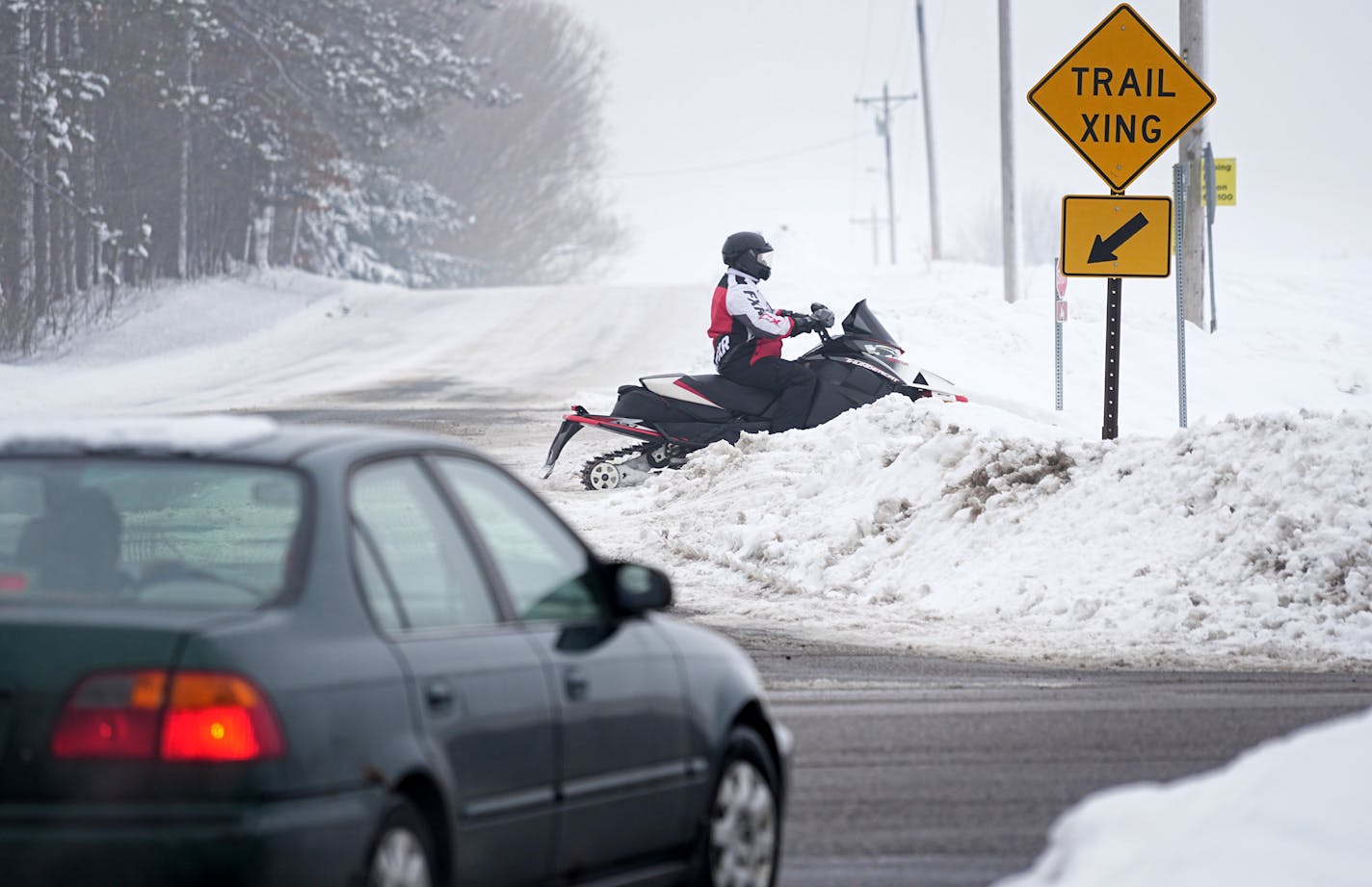 With early heavy snowfall throughout Minnesota, itÕs been a perfect winter for snowmobiling. That increase in activity has also led to an increase in snowmobile related accidents and deaths. Here, snowmobilers on the Star Trail between Forest Lake and Hugo have to navigate high snowbanks and traffic at road crossings. Tuesday, Jan. 10, 2023 in Hugo, Minn. The state has seen 6 deaths from snowmobiling this winter already. Only 6 people died in such accidents throughout the entirety of last winter. ] Brian Peterson ¥ brian.peterson@startribune.com