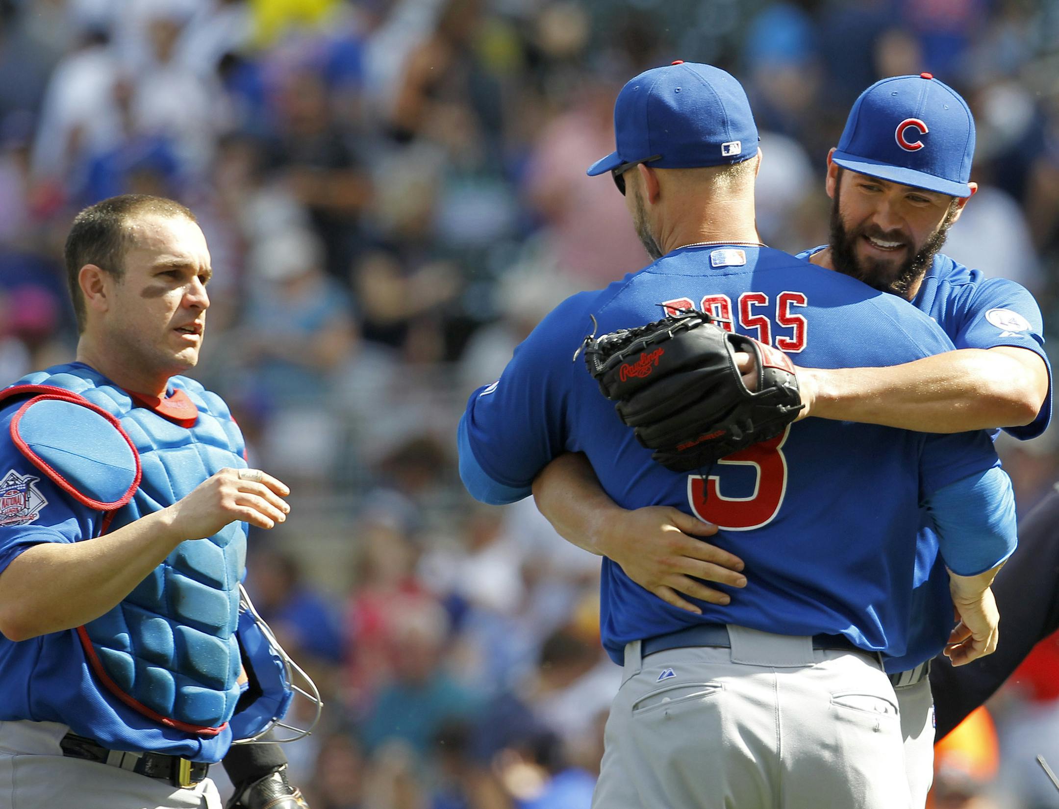 Chicago Cubs starting pitcher Jake Arrieta, right, and catcher Miguel Montero, left, celebrate with David Ross (3) after the Cubs defeated the Minnesota Twins 8-0 in a baseball game in Minneapolis, Sunday, June 21, 2015. (AP Photo/Ann Heisenfelt)