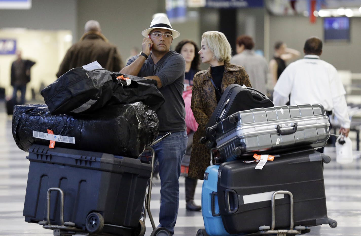 FILE - In this Dec. 1, 2013 file photo, travelers walk through terminal 3 baggage claim at O'Hare International airport in Chicago. The government reported Monday, May 5, 2014, that U.S. airlines raised $3.35 billion from bag fees in 2013, down 4 percent from 2012. That&#x2019;s the biggest decline since fees to check a bag or two took off in 2008. (AP Photo/Nam Y. Huh, File)