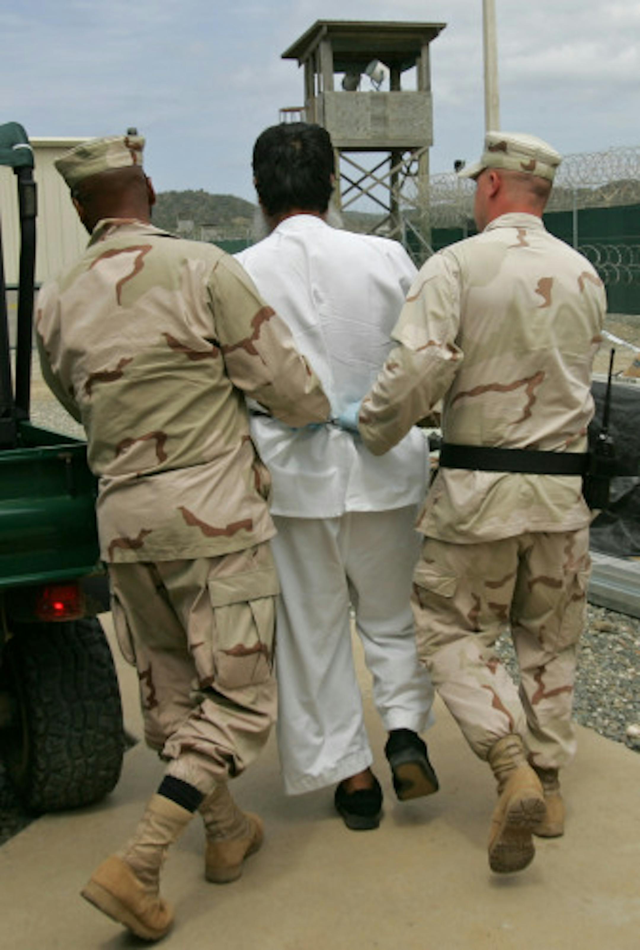 A detainee is moved by military guards at the detention center at Guantanamo Bay Naval Base, Cuba in this May 1, 2007 file photo. The Supreme Court is scheduled to consider whether the 300-plus prisoners held at Guantanamo, most of whom have never been charged with a crime, can go to U.S. courts to challenge their confinement.