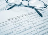 Medicare enrollment form and glasses. istock