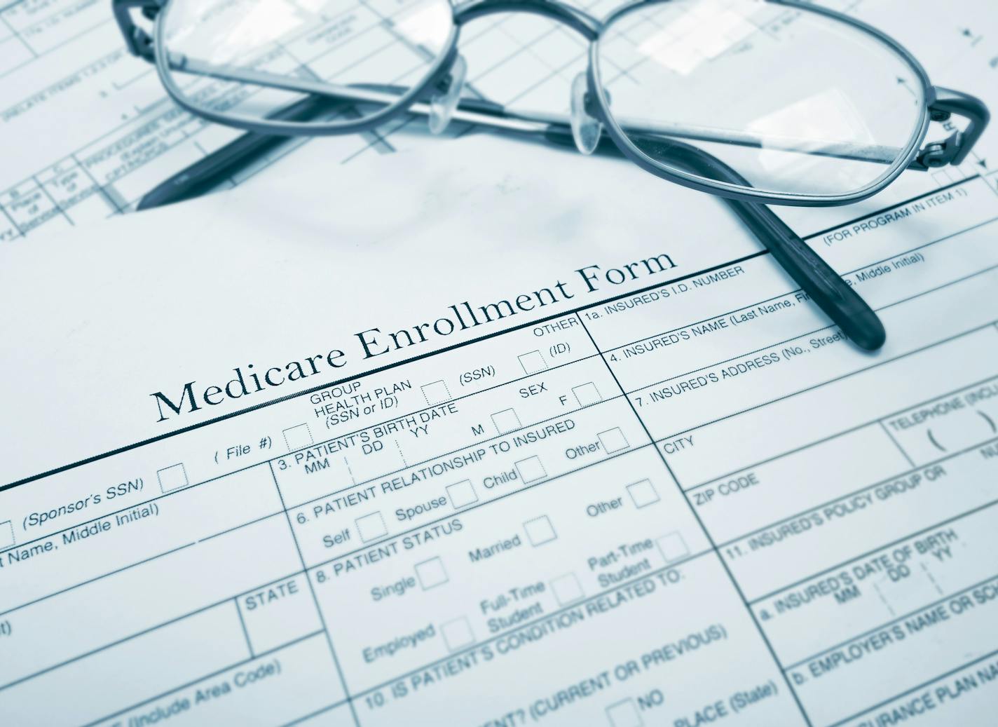 Medicare enrollment form and glasses. istock