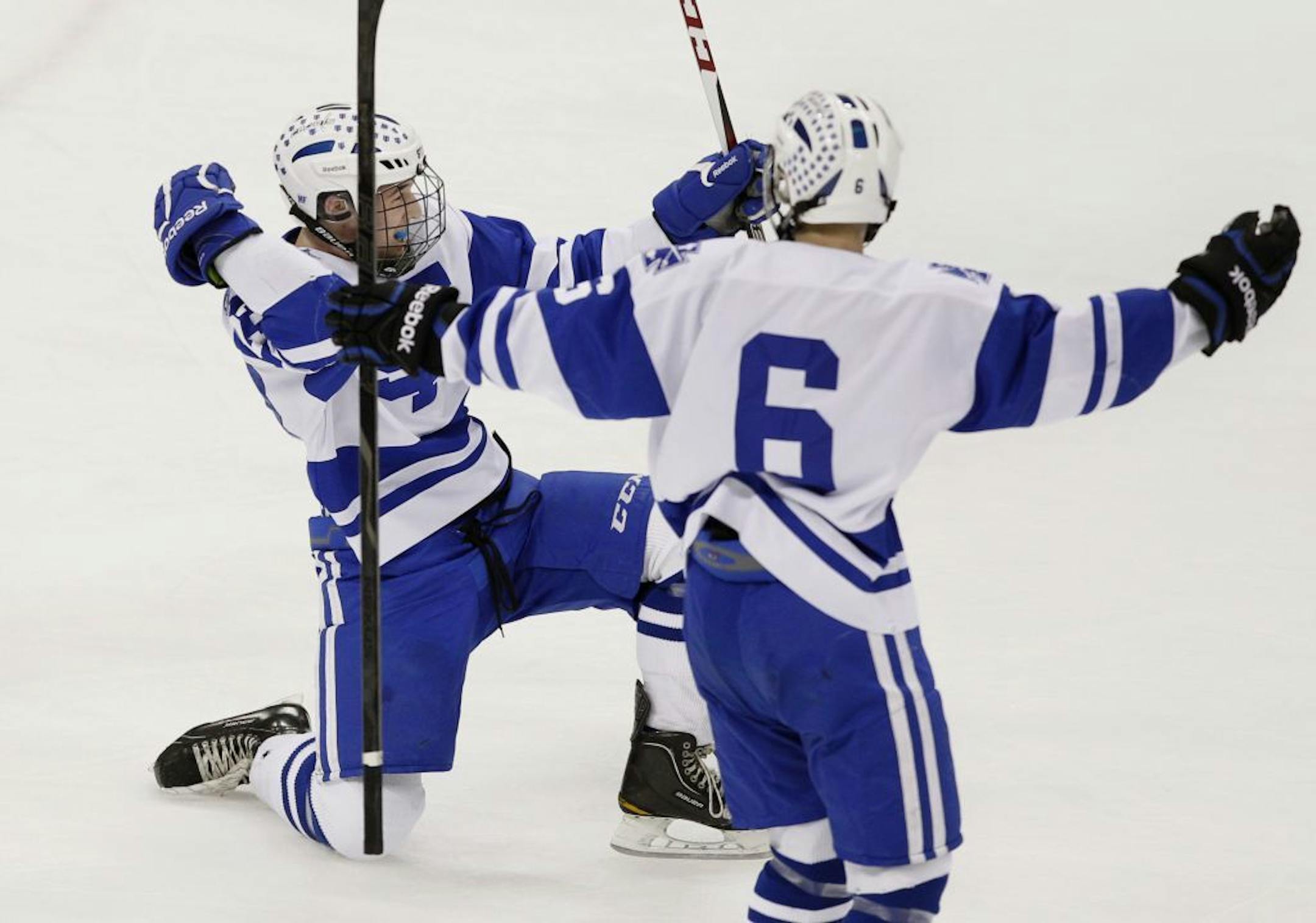 St. Thomas Academy's Matt Perry, left, celebrates with teammate Tony Bretzman (6) after scoring on Hermantown High School goalie Adam Smith during the first period of the Minnesota Class 1A championship boys high school hockey game Saturday March 9, 2013 in St. Paul, Minn.