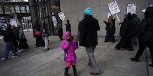 At the Securian Center in downtown St. Paul, several dozen janitors from the SEIU, including Mohamed Geyre with his daughter Fadumo,6, protested their
