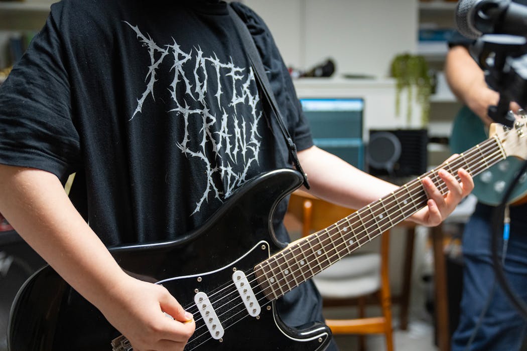 Dave Annis’s transgender son, who asked to remain anonymous, plays guitar with his father while wearing a Trans Action Apparel shirt designed by Cory Tobin.