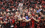 Atlanta United team captain Michael Parkhurst, center, kissed the MLS Cup trophy as teammates celebrate after they defeated the Portland Timbers 2-0 i