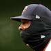 Minnesota Twins first baseman Miguel Sano (22) keeps warm with a face mask.