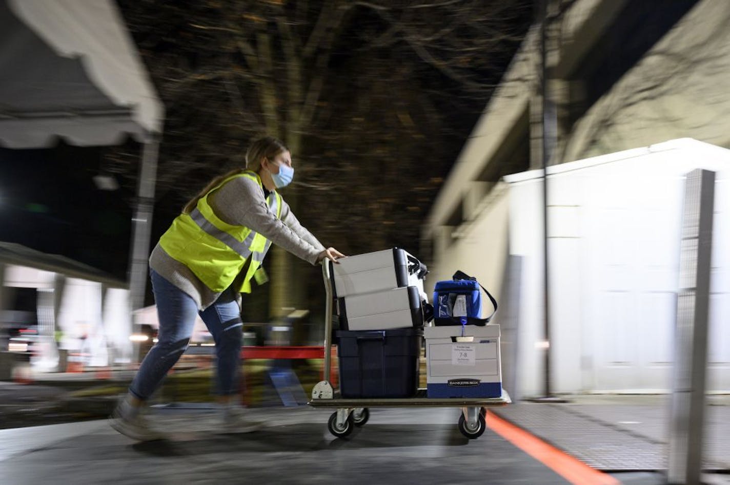 Anna Baish, a volunteer and student at the University of Minnesota, pushed a dolly holding completed ballots and election equipment into the warehouse at the Ramsey County Elections Office on Tuesday night.