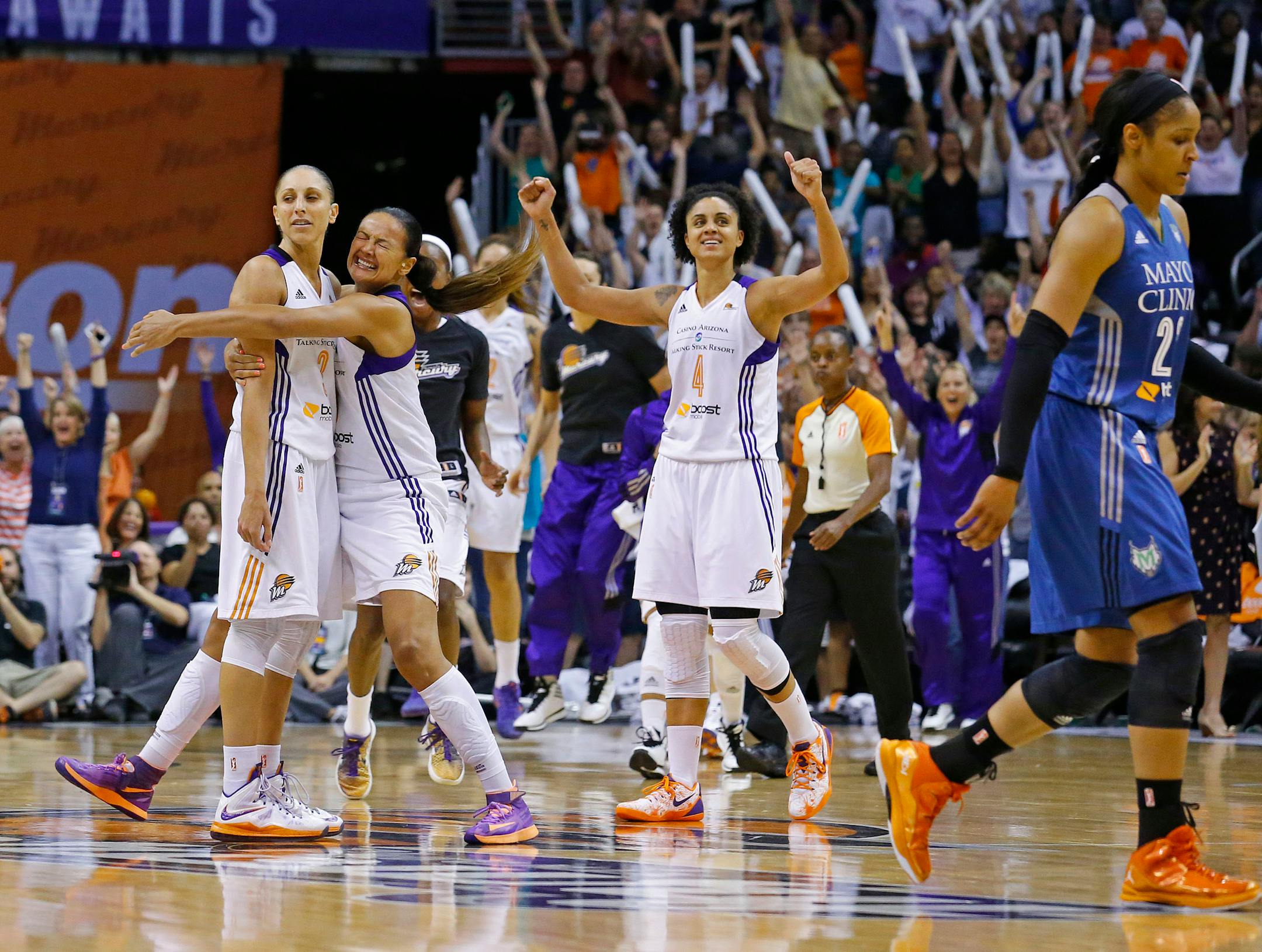 Phoenix Mercury forward Mistie Bass (8) celebrates with Phoenix Mercury guard Diana Taurasi (3) after her half court 3 point shot to end the 3rd quarter against the Minnesota Lynx in game 3 of the WNBA Western Conference finals Tuesday, Sept. 2, 2014 in Phoenix Ariz.