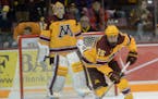 Gophers forward Justin Kloos takes the puck away from the net.] During the first period. BRIDGET BENNETT SPECIAL TO THE STAR TRIBUNE � bridget.benne