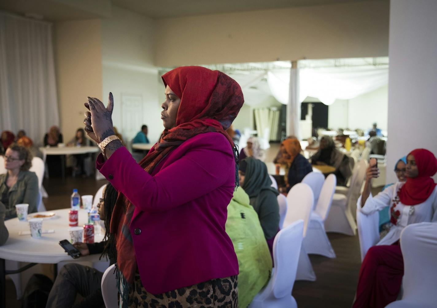 Deqa Hussein took pictures as Rep. Mary Franson spoke during a community FGM (female genital mutilation) eduction awareness meeting in Minneapolis, Minn., on Thursday, May 18, 2017. Hussein also spoke out at the event encouraging women to be proactive in protecting children.