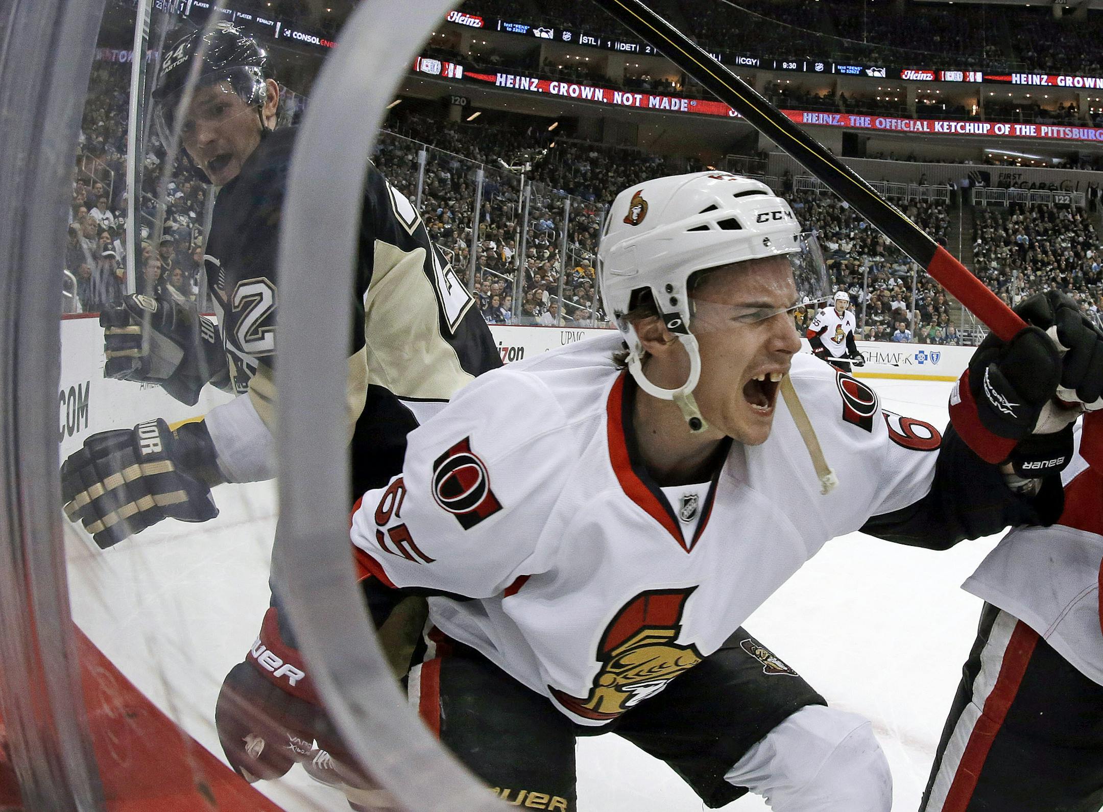 Ottawa Senators defenseman Erik Karlsson (65) grimaces as he falls to the ice after colliding with Pittsburgh Penguins left wing Matt Cooke, left, during the second period of an NHL hockey game in Pittsburgh Wednesday, Feb. 13, 2013. Karlsson was helped off the ice. (AP Photo/Gene J. Puskar) ORG XMIT: PAGP105 ORG XMIT: MIN1307051950192320