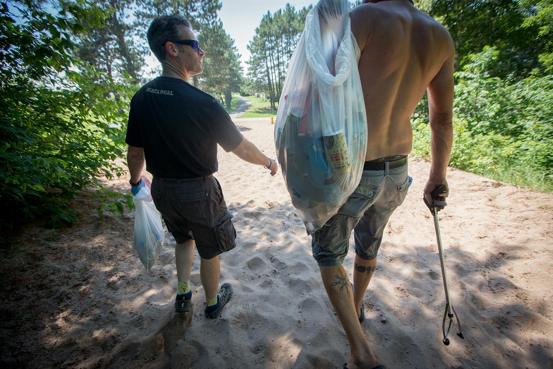 Duluth Judge Shaun Floerke, left, cleaned Park Point beach before having a picnic with DWI defendants, Friday, July 28, 2017 in Duluth, MN.