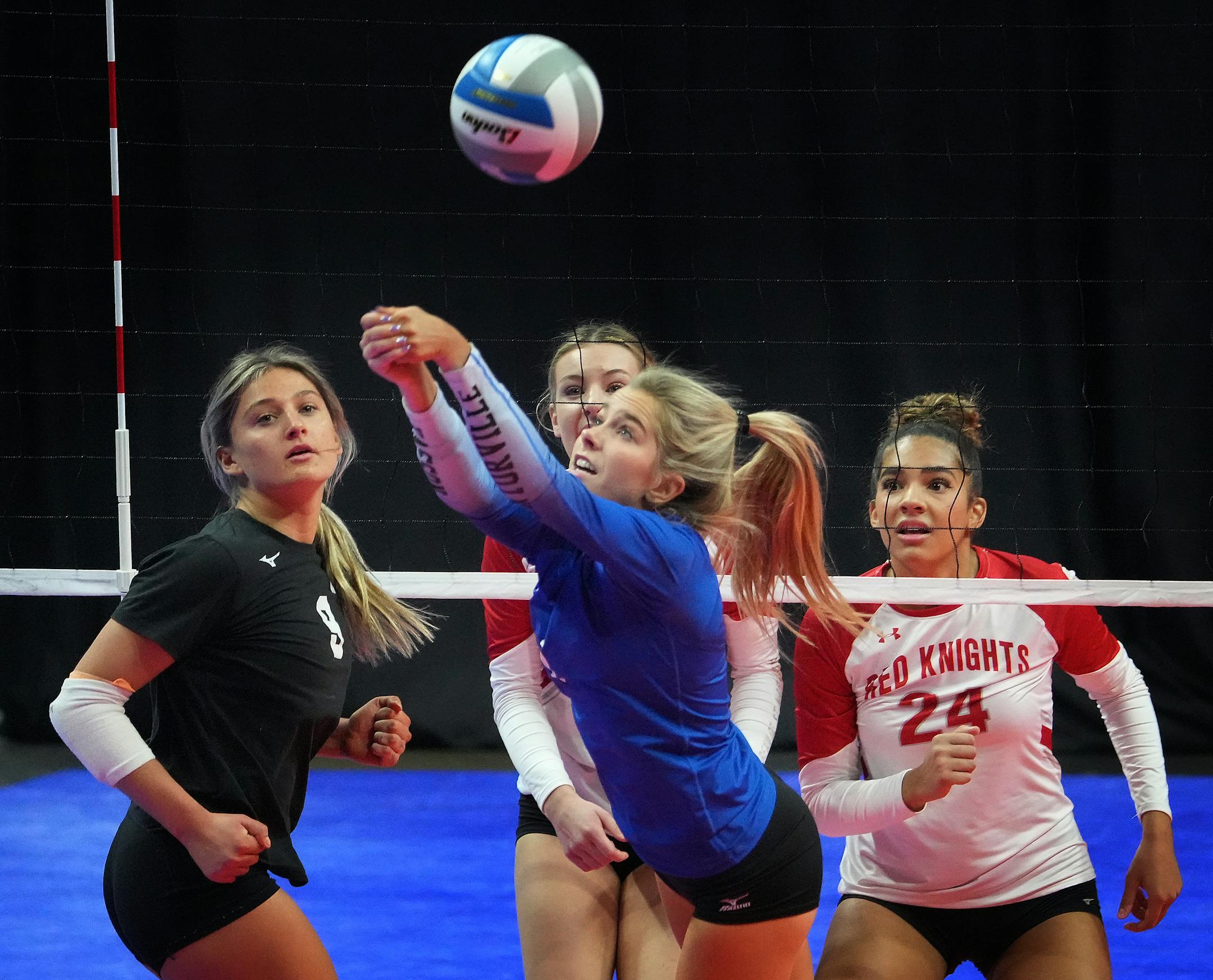 Kasson-Mantorville's Aryss McAdams (1) bumps a shot as teammate Whittney Deno (9) looks on along with Benilde-St. Margaret's Sierra Lumpkin (24).
