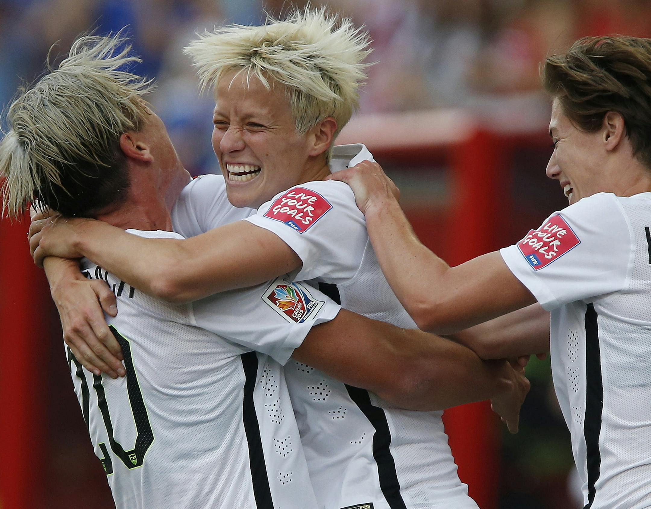 United States' Megan Rapinoe, center,, Abby Wambach (20) and Meghan Klingenberg (22) celebrate Rapinoe's goal against Australia during a FIFA Women's World Cup soccer match in Winnipeg, Manitoba, Monday, June 8, 2015. (John Woods/The Canadian Press via AP) MANDATORY CREDIT
