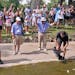 A cameraman films and the gallery cheers as Emiliano Grillo's ball comes to a rest against a rock after floating down a concrete drainage canal on the