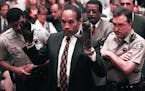 O.J. Simpson holds his hands up to the jury during testimony in Los Angeles Thursday, June 15, 1995, to show the bloody gloves the prosecution says he