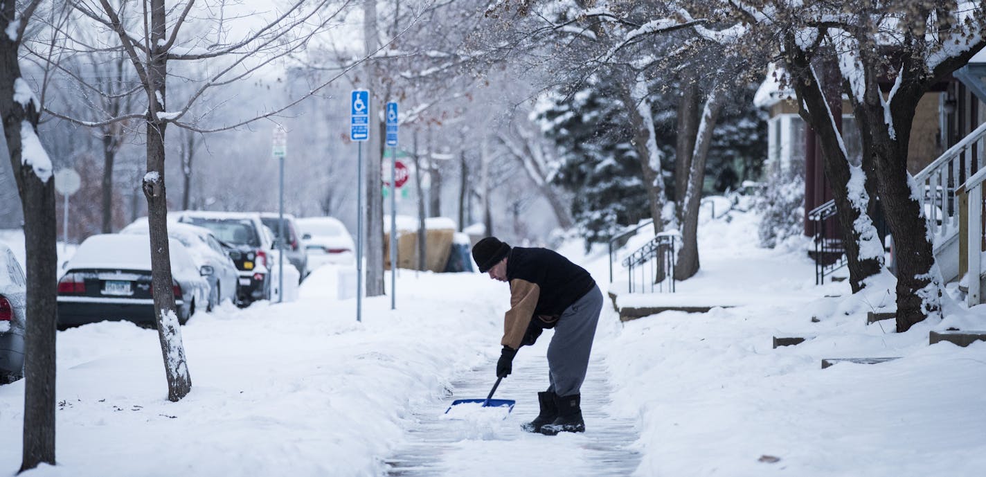 A man shovels the sidewalk on S. 8th Street near Riverside Avenue in Minneapolis. ] (Leila Navidi/Star Tribune) leila.navidi@startribune.com BACKGROUND INFORMATION: (NOTE - He did not want to give his name) Morning commute in Minneapolis after a weekend of snow on Monday, December 12, 2016. Minneapolis, St. Paul and a number of suburbs including West St. Paul, St. Louis Park and Plymouth declared snow emergencies late Sunday morning and into Monday.