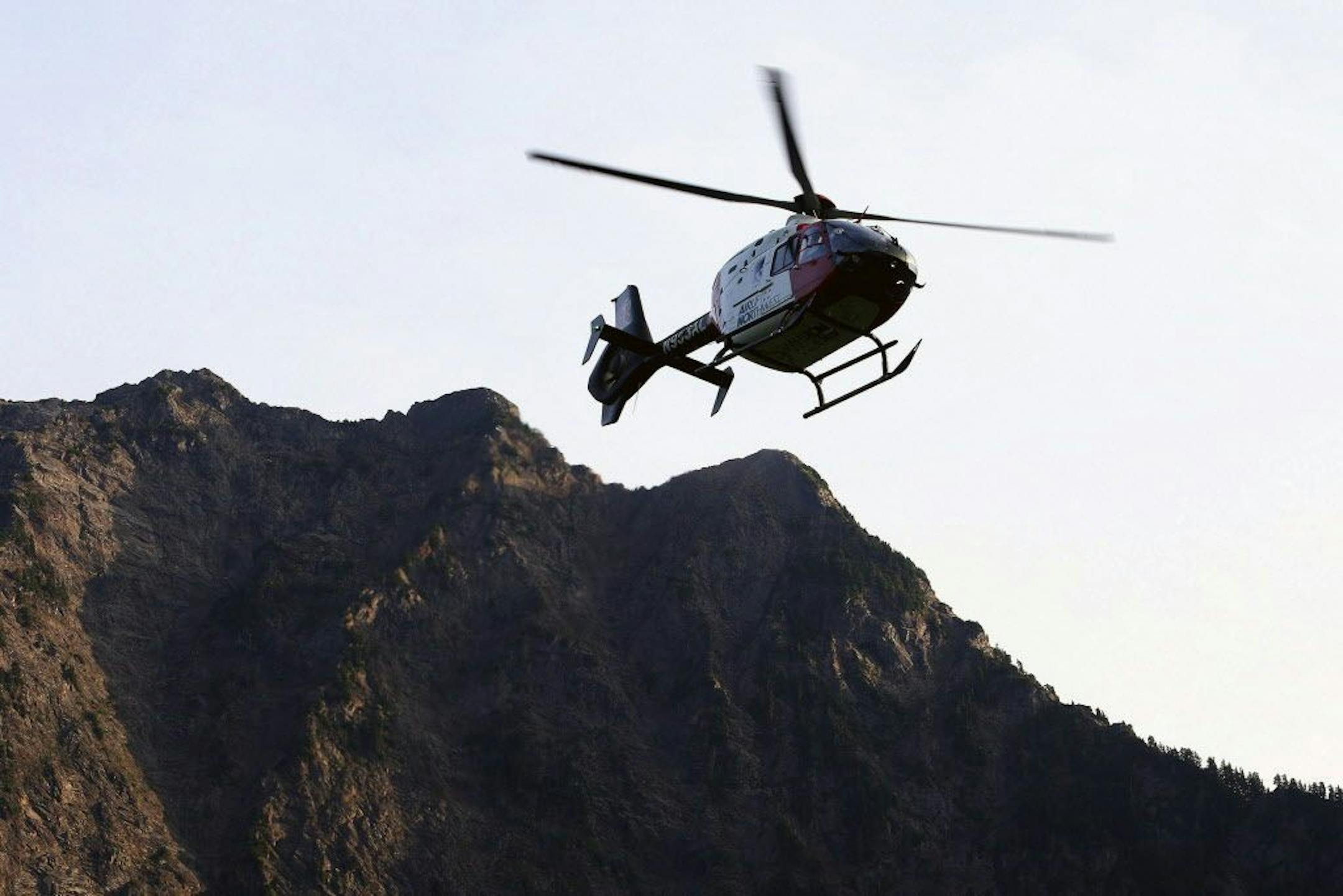 FILE - In this July 6, 2015, file photo a helicopter transports an injured woman to a hospital near the Big Four trail head in Verlot, Wash.