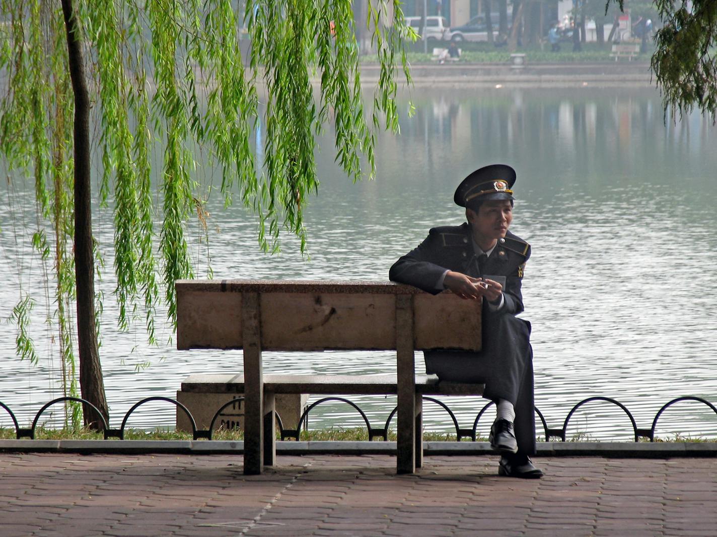 A policeman enjoys a break by Hoan Kiem Lake in central Hanoi. The Old Quarter is on the north and west sides of the Lake.