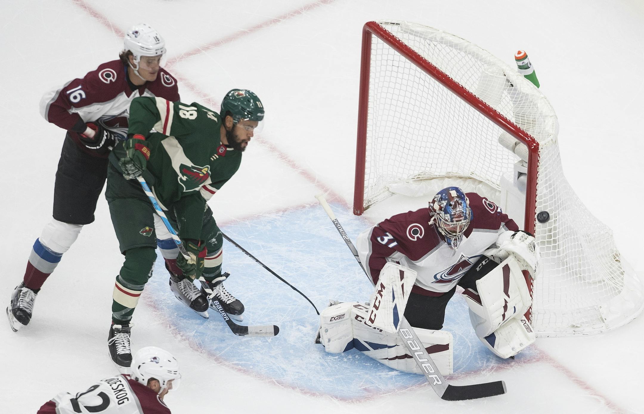 Colorado Avalanche goalie Philipp Grubauer (31) makes the save as Minnesota Wild's Jordan Greenway (18) and Avalanche's Nikita Zadorov (16) look for the rebound during the first period of an exhibition NHL hockey game in Edmonton, Alberta, Wednesday, July 29, 2020. (Jason Franson/The Canadian Press via AP)