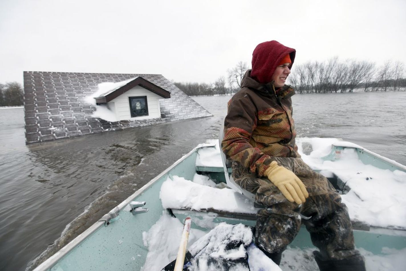 March 2009: Michael Stensgard used one of his family's boats to go past a neighbor's house on the way to his home as the Red River crested at Fargo-Moorhead .