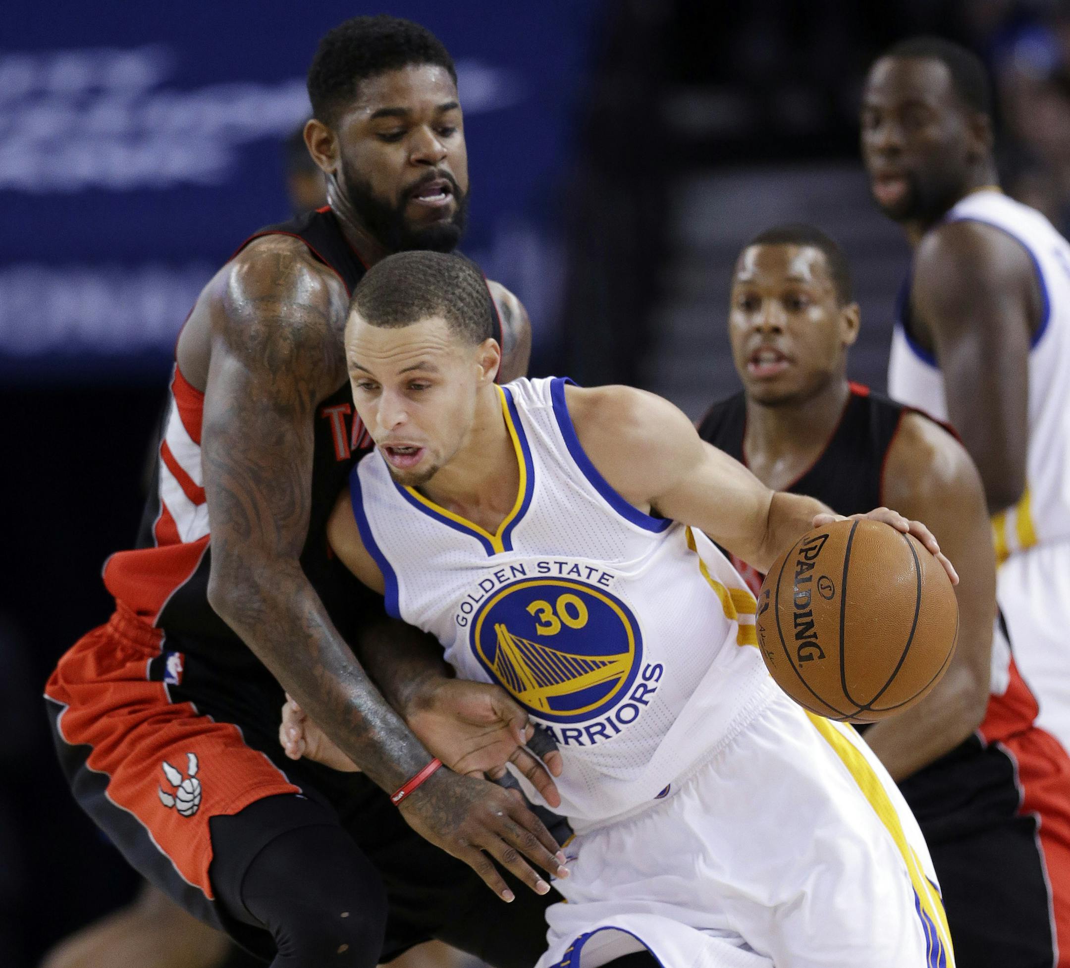 Golden State Warriors' Stephen Curry (30) is defended by Toronto Raptors' Amir Johnson during the first half of an NBA basketball game Friday, Jan. 2, 2015, in Oakland, Calif. (AP Photo/Marcio Jose Sanchez)