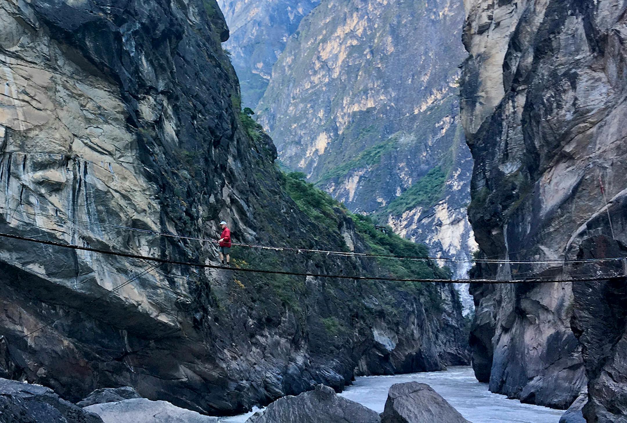 For a small fee, a hiker gained access to a primitive bridge leading to a rock in the middle of the Jinsha River that offers a scenic view.