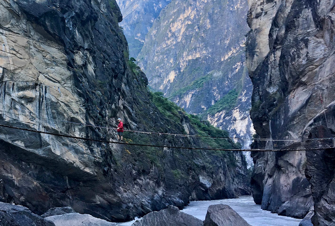 For a small fee, a hiker gained access to a primitive bridge leading to a rock in the middle of the Jinsha River that offers a scenic view.