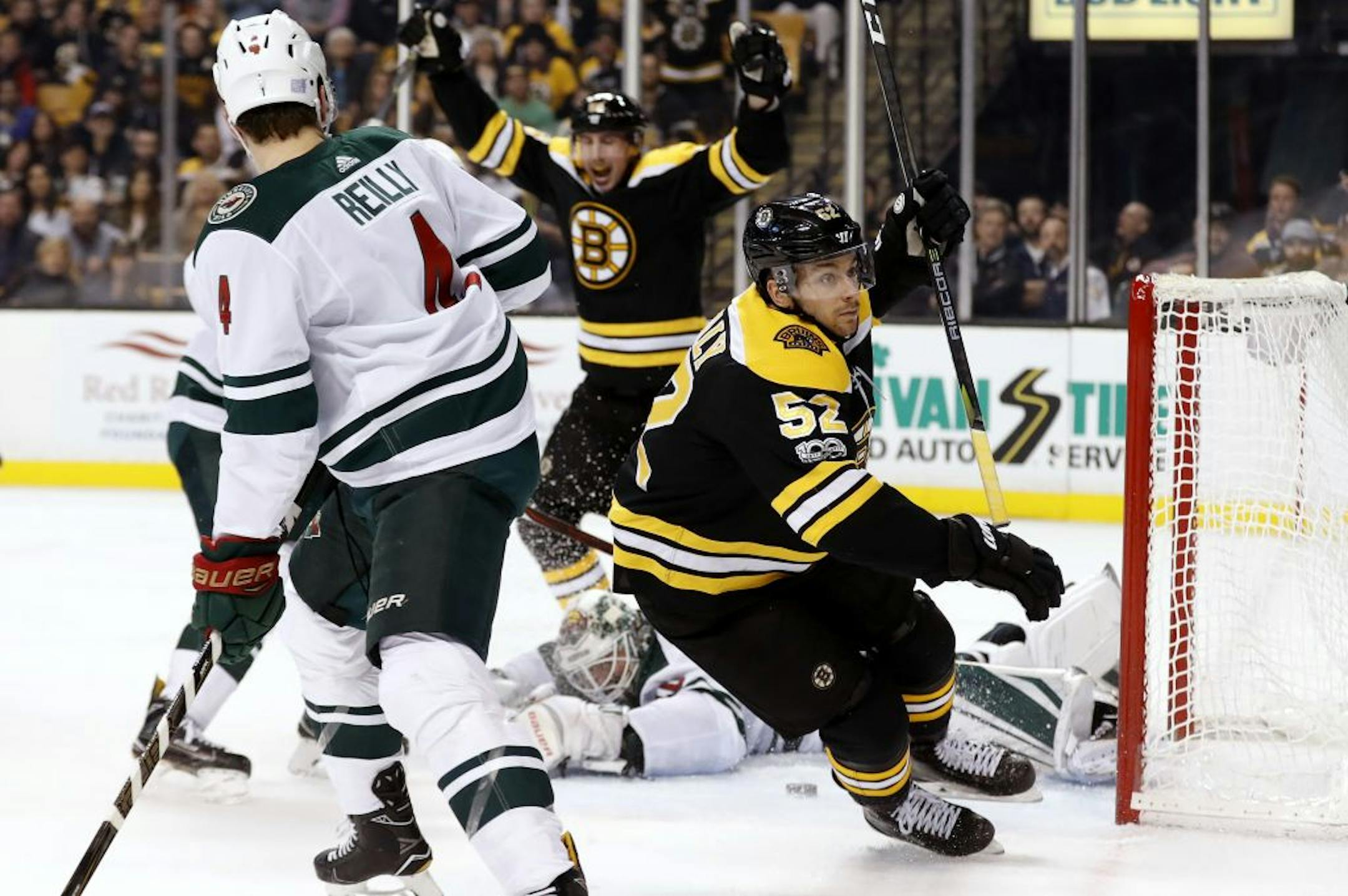 Boston Bruins' Sean Kuraly celebrates his goal on Minnesota Wild goalie Devan Dubnyk as defenseman Mike Reilly (4) looks on during the second period of an NHL hockey game in Boston Monday, Nov. 6, 2017.