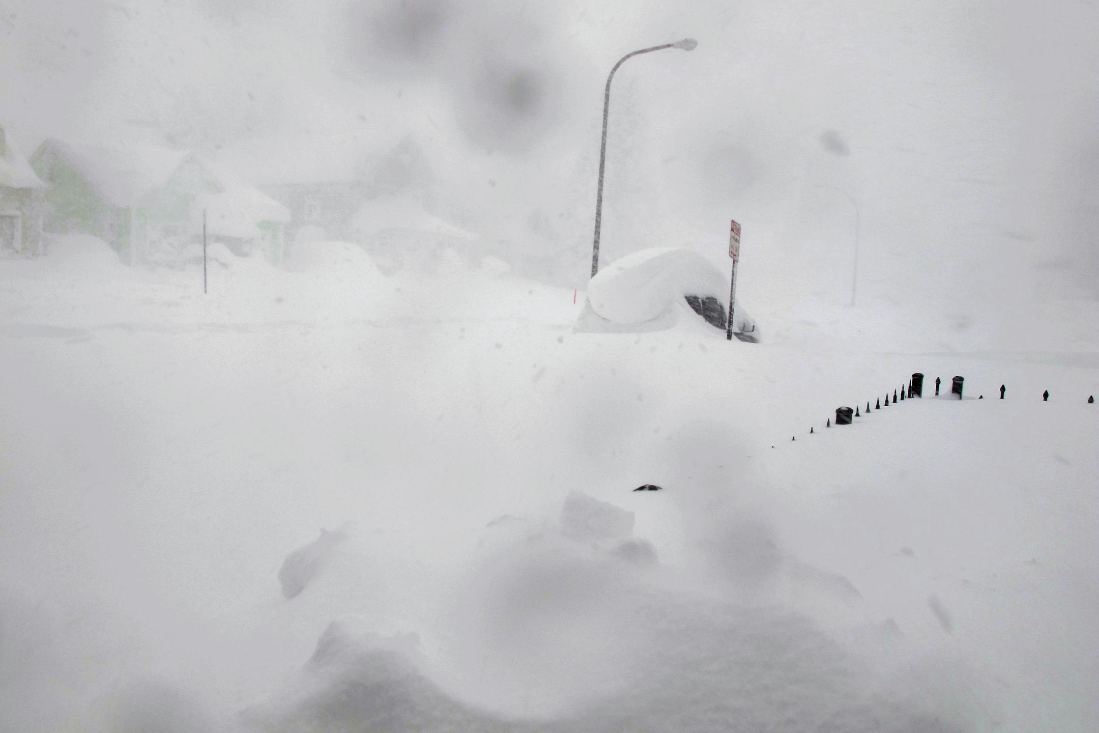 A 4-foot fence and SUV are nearly buried along a street in Buffalo, N.Y. on Tuesday, Nov. 18, 2014.