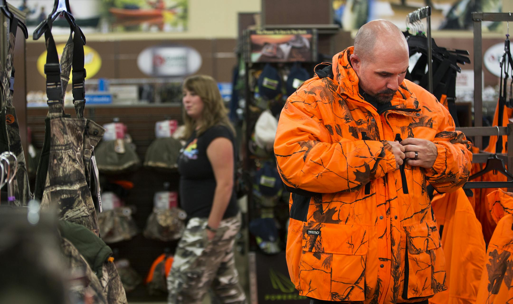 Lane Gehrman of Osceola, Wis., tried on a blaze camouflage hunting jacket at Gander Mountain in Blaine, Minn. on Friday, October 31, 2014. ] RENEE JONES SCHNEIDER • reneejones@startribune.com