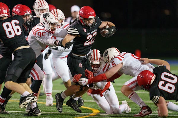 Eden Prairie linebacker Dominic Heim (22) carries the ball taken down by Lakeville North linebacker AJ Pacyga (45), defensive back Max Melin (6) and d