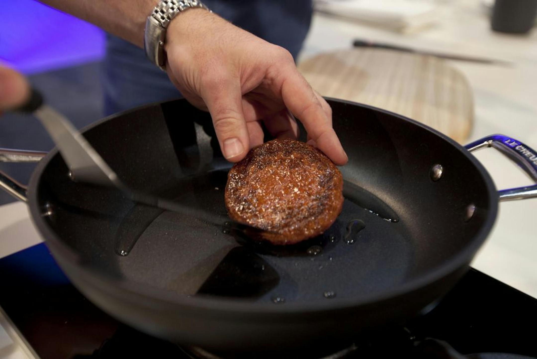 A new Cultured Beef Burger made from cultured beef grown in a laboratory from stem cells of cattle, is cooked by chef Richard McGeown during the world's first public tasting event for the food product held in London, Monday Aug. 5, 2013. The cultured beef product was developed by Professor Mark Post, not pictured, of Netherland's Maastricht University. The Cultured Beef could help solve the coming food crisis and combat climate change according to the producers of the burger which cost some 250,