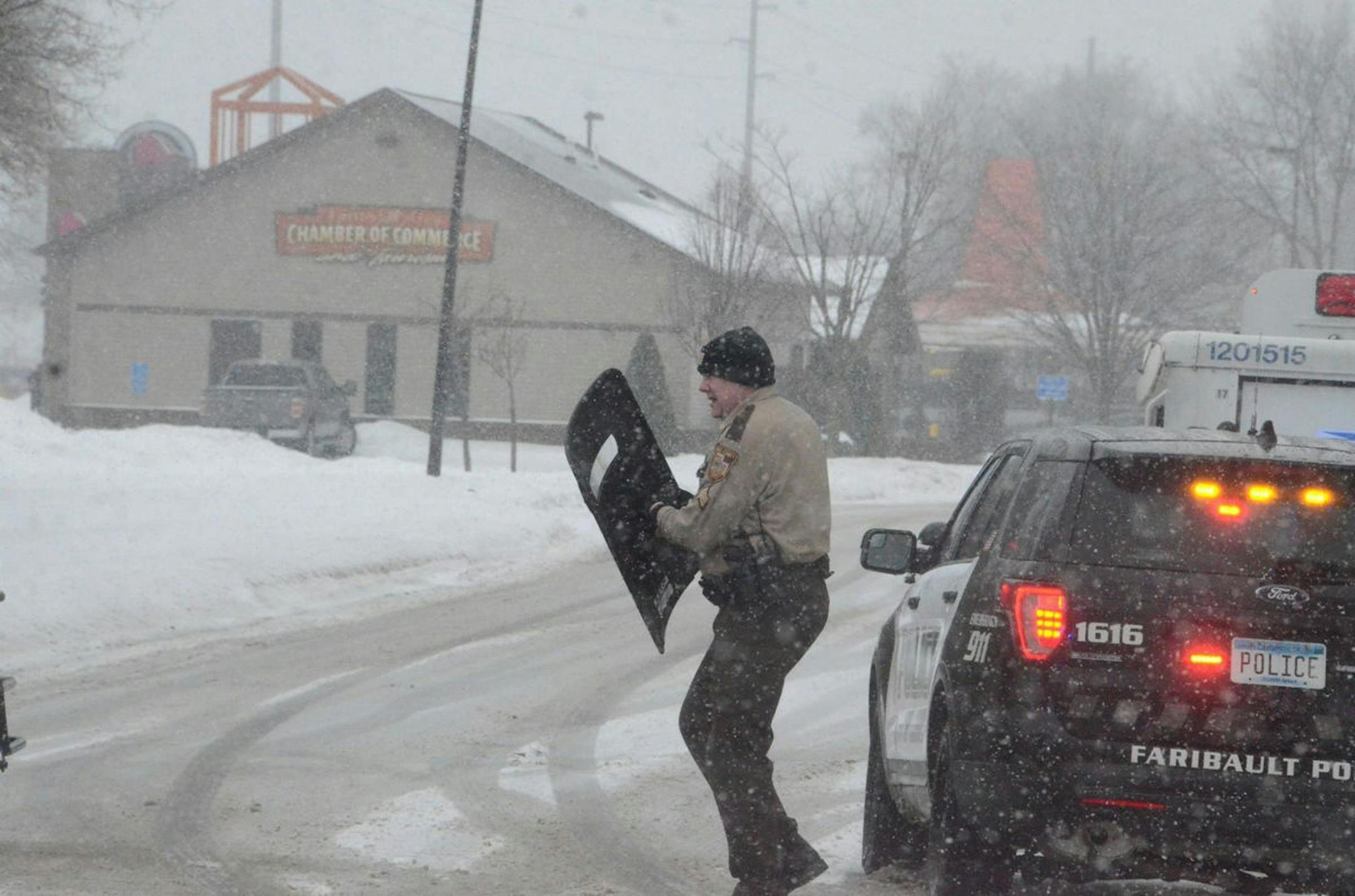 A Rice County deputy takes out equipment before heading toward the Faribault Chamber of Commerce building on Wilson Avenue. The road was blocked off at Seventh Street and Hwy. 60 Friday afternoon.