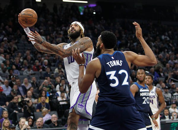 Kings center Willie Cauley-Stein gets around Timberwolves center Karl-Anthony Towns for a shot during the second half Friday.