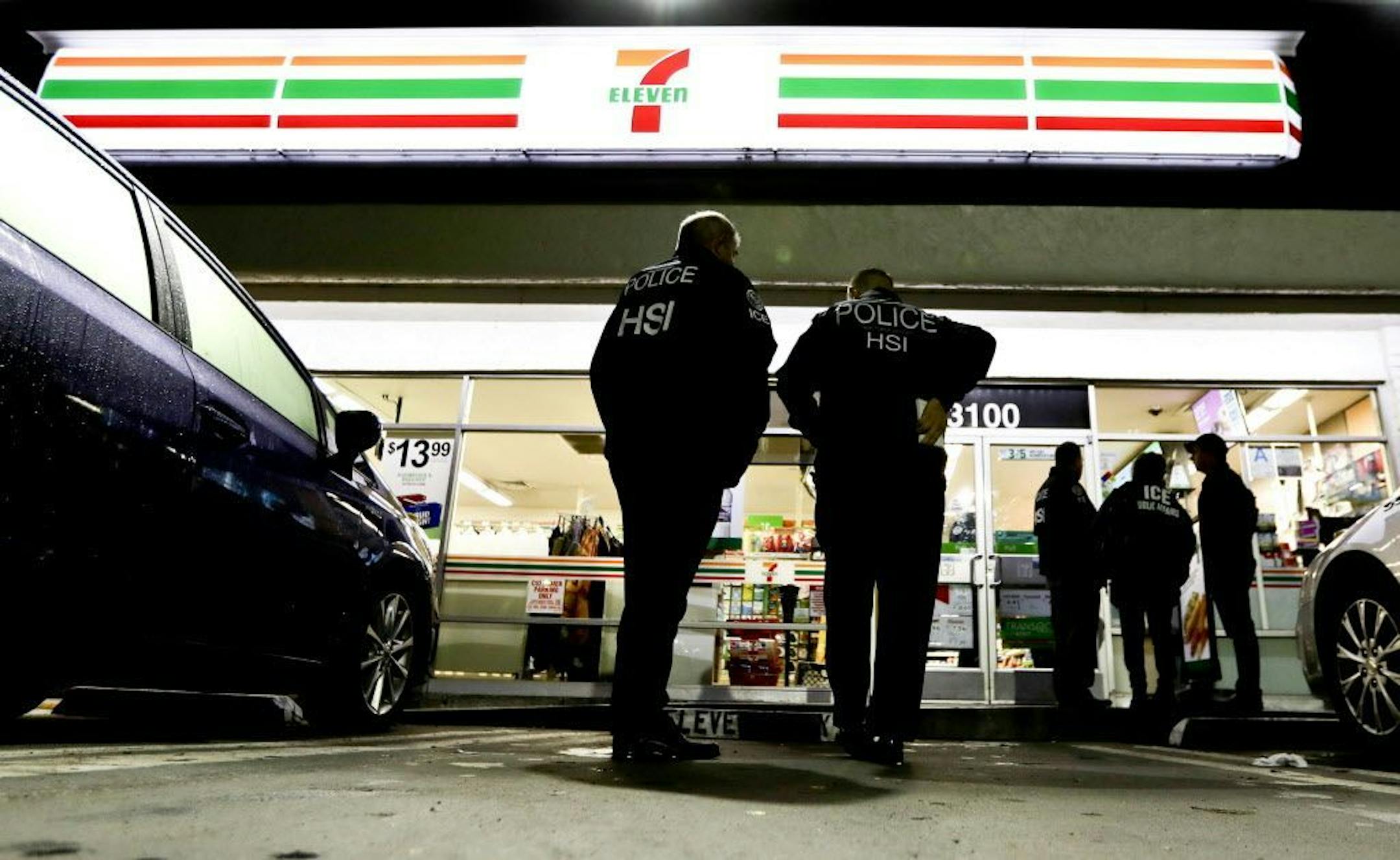 U.S. Immigration and Customs Enforcement agents serve an employment audit notice at a 7-Eleven convenience store Wednesday, Jan. 10, 2018, in Los Angeles. Agents said they targeted about 100 7-Eleven stores nationwide Wednesday to open employment audits and interview workers.