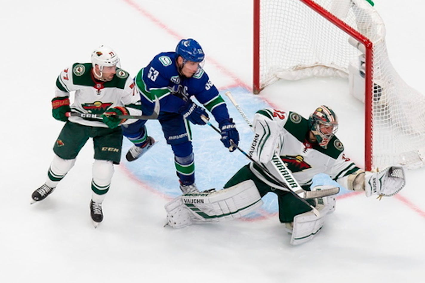 Vancouver's Bo Horvat, center, pestered Wild goalie Alex Stalock while battling defenseman Brad Hunt during Tuesday night's Game 2 of the Western Conference qualifying series.