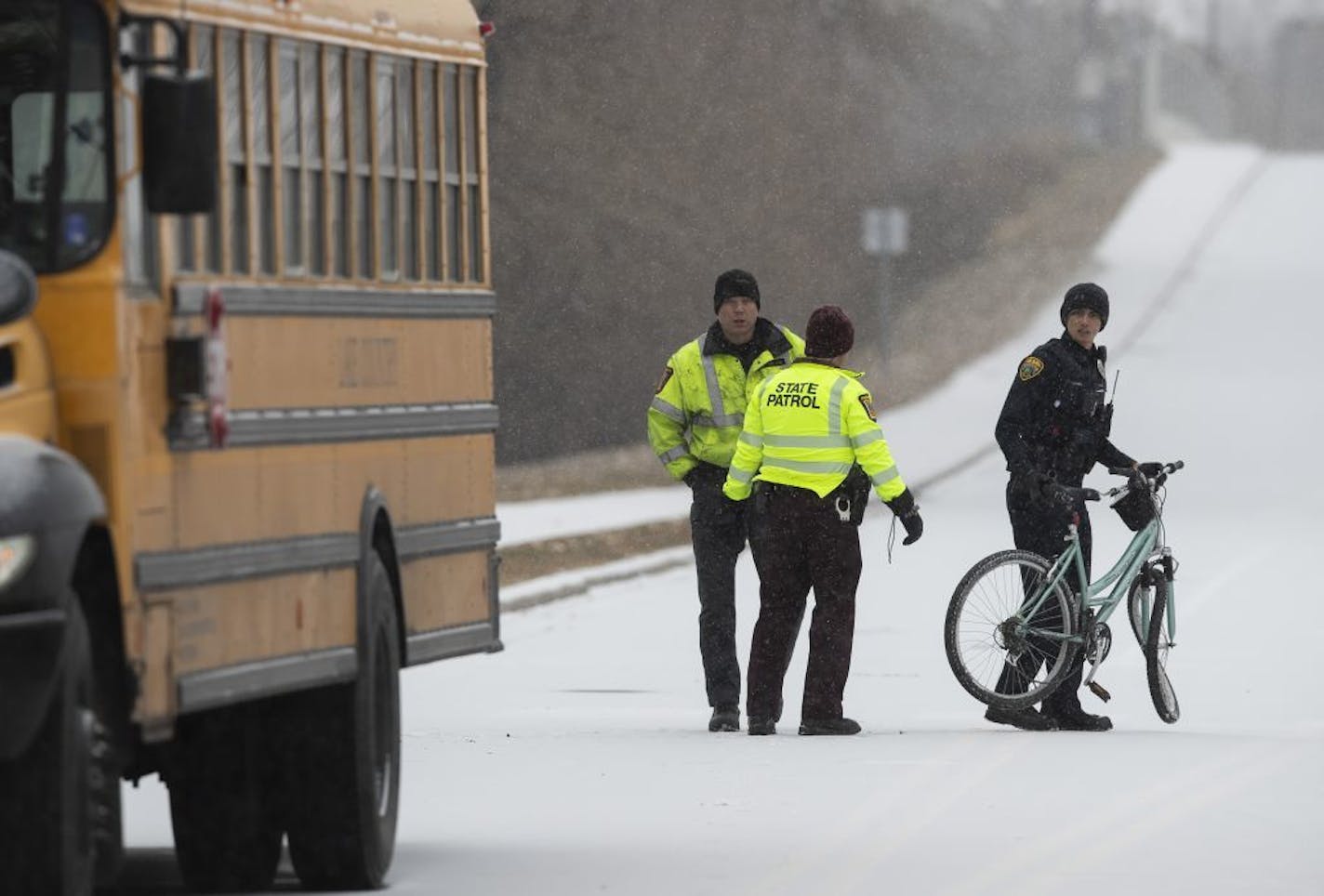 A Brooklyn Park Police officer carries a bicycle away from the scene where a bicyclist was killed after colliding with a school bus Wednesday morning on Zane Avenue and 65th Avenue in Brooklyn Park.